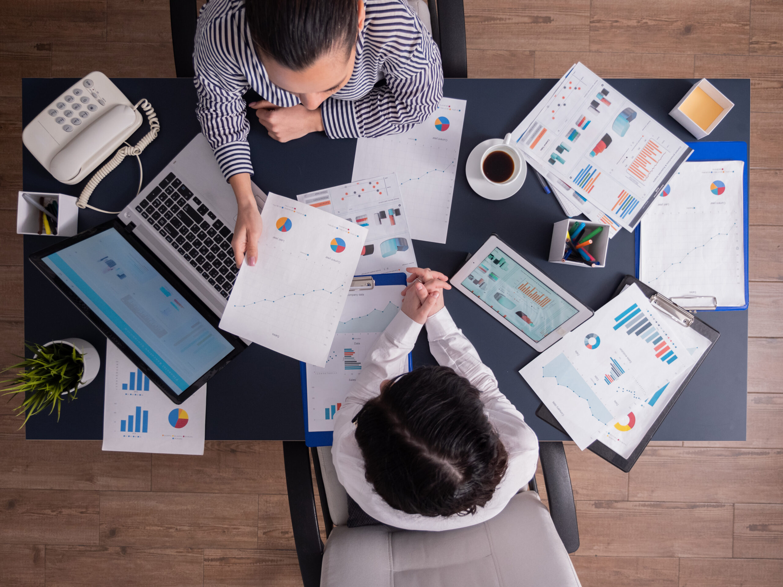 Top view of office workers meeting analyzing financial charts